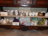 many cups and saucers on a shelf in a room