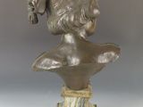 un buste antique en bronze représentant une femme coiffée d'un chapeau