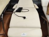 une table de massage blanche sur laquelle se trouve une télécommande
