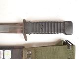 a knife that is laying on top of a green belt