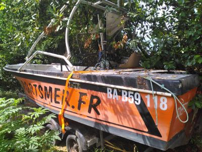 an orange and black boat that is sitting in the grass