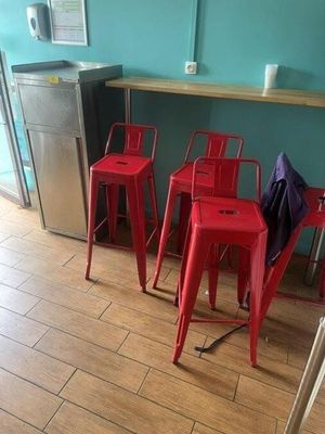 three red chairs sitting in front of a counter