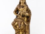 a gold statue of a woman holding a cat on a white background