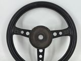 a close up of a steering wheel on a white surface