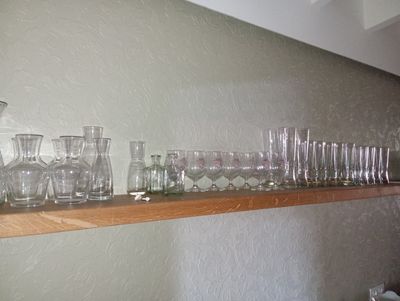 many glasses on a shelf in the kitchen