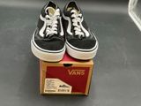 pair of black and white vans sneakers sitting on top of a box