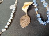 a necklace with a coin on it and a necklace with a coin on it
