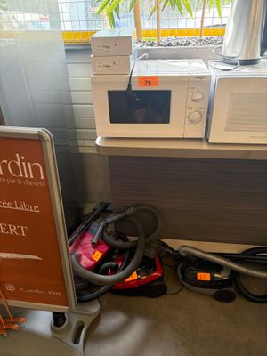 two microwaves and a stroller in a room