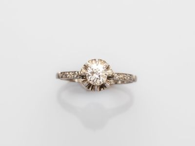 une bague de fiançailles avec un diamant au centre, sur fond blanc