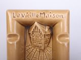 a brown vase that has a picture of a house in it