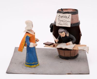 a figurine of a woman standing next to a barrel of wine