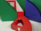 four different colored books on a white table