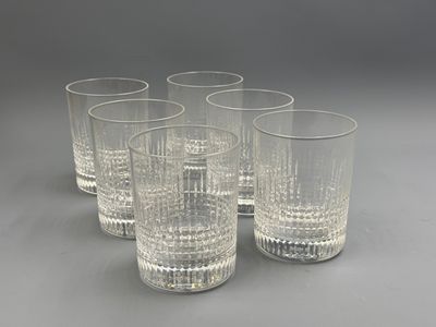 six verres à eau en verre transparent alignés sur une surface grise