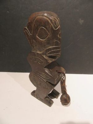 statue of a man sitting on a stool with a phone in his hand