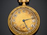 gros plan d'une montre de poche en or sur une surface noire
