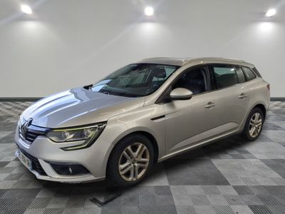 une voiture argentée est garée sur le sol à carreaux d'un garage