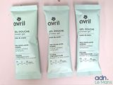 two packets of gel douche sitting next to each other on a pink surface