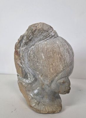 sculpture of a woman ' s head on a white surface