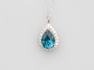 a blue topaz and diamond pendant on a silver chain