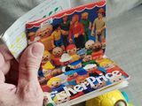 a person holding a magazine with a bunch of toys on it
