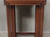 un ensemble de trois tables gigognes en bois sur fond gris