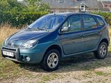 a small blue car parked on the side of the road