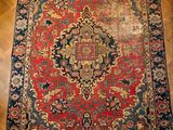 un tapis oriental rouge et bleu posé sur un parquet