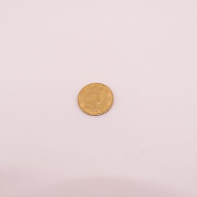 gros plan d'une pièce d'or sur une surface blanche