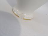 a close up of a white vase with gold trim on it