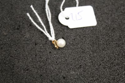 une étiquette blanche ornée d'une perle, posée sur une surface noire