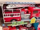 a toy fire engine that is in a box on the table