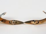 pair of gold cufflinks on white surface with white background