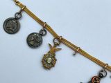 a close up of a gold necklace with charms on a white surface