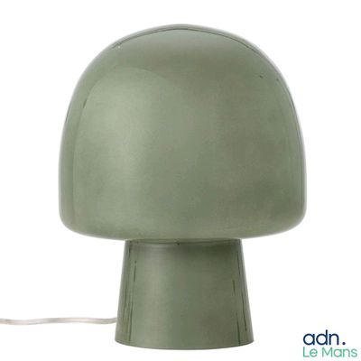 une lampe verte posée sur une table blanche