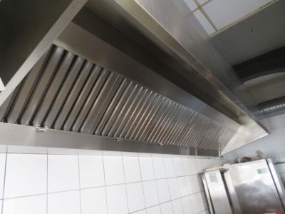 une photo d'une hotte en acier inoxydable dans une cuisine professionnelle