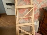 a tall wooden ladder next to a dresser in a room