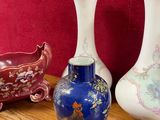 three vases sitting on a wooden table with a red background