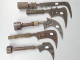 five old and rusty knives are lined up on a white surface