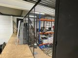 a picture of a room with a metal fence and shelves