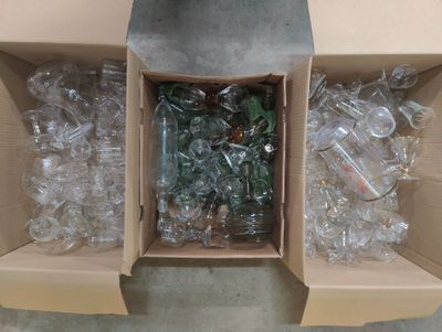 une boîte remplie de bouteilles vides posée par terre