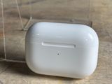 Des AirPods Apple sont posés sur une table, dans un étui transparent.