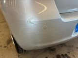 a close up of a car ' s front bumper with a denting on it