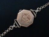an image of a silver bracelet with a picture of a cat on it