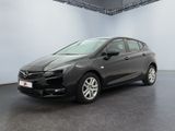 L'Opel noire est garée dans une grande pièce aux murs blancs.