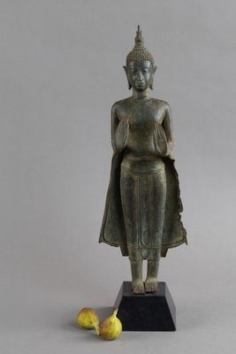 statue d'un Bouddha debout, avec deux bananes posées devant lui