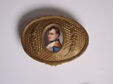 une boîte dorée sur laquelle figure l'image d'un homme