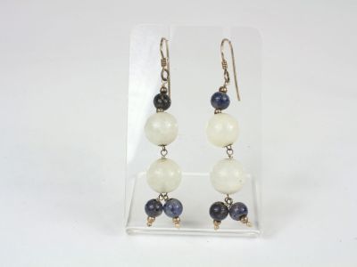 a pair of earrings with blue and white beads on them