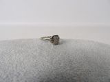 une photo d'une bague en diamant posée sur un coussin