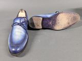 pair of men ' s blue leather shoes on a gray surface
