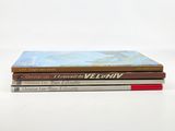 three books are stacked on top of each other on a white surface